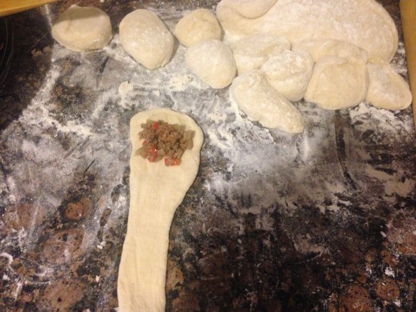 然後用桿麵棍，從上到下壓平如圖，大頭的部分放入適量的內餡材料如圖，然後從上往下捲起就是包好內餡的麵包卷了。