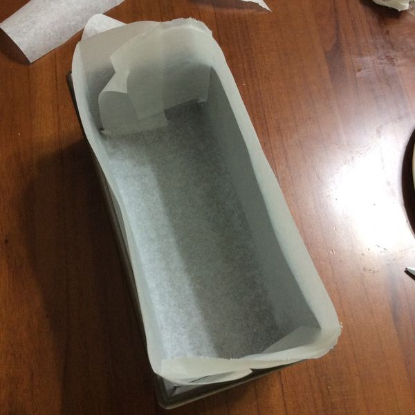 將烤盤紙摺好放入烤模