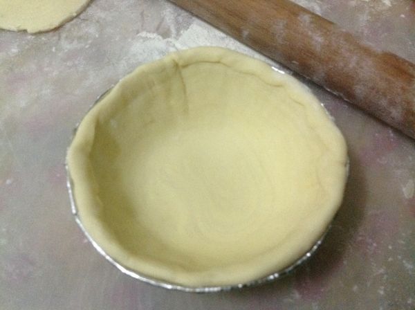 將酥皮捲切成0.9-1公分寬，切成10-12塊，灑點麵粉，擀成13公分寬的面皮，放於模型中。