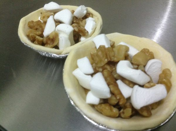 底層先放棉花糖小丁在放堅果在鋪上棉花糖小丁，即可進爐。建議將烤盤擺在下層烘烤，否則可能派皮未澎漲，堅果和棉花糖先焦掉