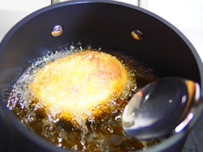 13.利用大湯匙將肉蛋輕輕的放入180度的油鍋裡，炸4分鐘(設定碼表)，如果蛋超過油的高度，可以利用大湯匙將熱油淋在肉蛋上面，慢慢炸。