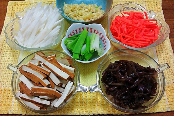 將白蘿蔔、紅蘿蔔、豆乾、木耳、蔥川燙待涼後，全部切絲。