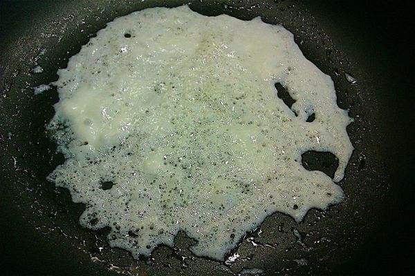 將步驟2之蛋白加油拌勻，倒於不沾鍋內，不再加油，待鍋邊蛋白已稍離鍋邊時，輕輕的整片拿起來，備用。