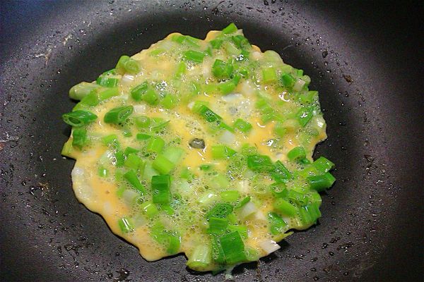 取一顆蛋加蔥拌勻，不沾鍋上放少許油，將蔥蛋倒於不沾鍋上小火煎，可暫時不開火。