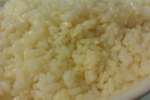 將飯泡於蛋黃內，用手抓一抓，讓蛋黃均勻於飯粒，加些沙拉油再拌勻。