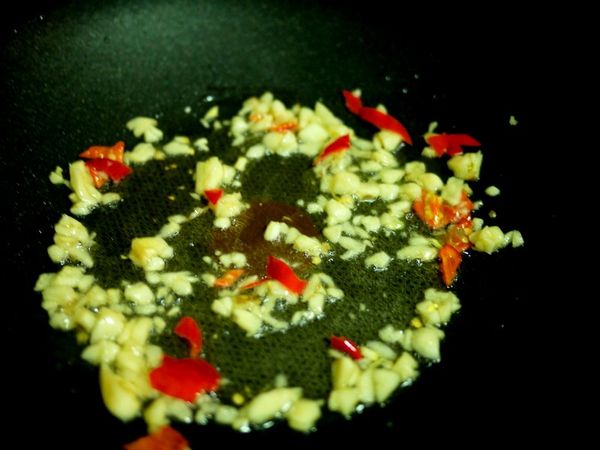 先下一大匙油熱鍋後,加入蒜粒、辣椒拌炒至香氣出來