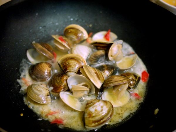 不到2分鐘開始有蛤蜊陸續打開囉...
約開八成可以加入九層塔拌炒一下,
即可上桌