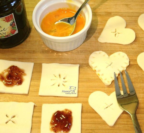 果醬塗在底部酥皮，在周圍用少許水塗抹一圈（像包水餃一樣）。把有刻花紋的上方酥皮蓋在底部酥皮上，拿叉子在四周按壓緊。