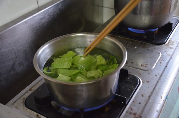 把長年菜切段用滾水燙過