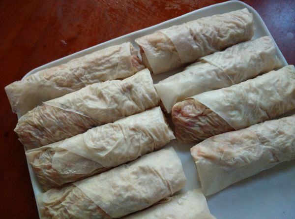 使用包捲法，用雞捲皮將內餡包捲成長條狀，分次把所有的內餡包捲完成。