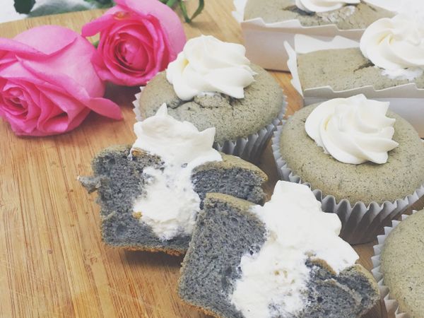 鮮奶油加糖粉打發裝進擠花嘴袋再插入蛋糕中,將適量的鮮奶油擠入杯子蛋糕