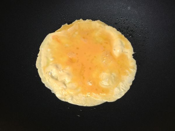 鍋內倒入適當的橄欖油，將打散的蛋汁倒入鍋內，滾動鍋子讓鍋中蛋液均勻滾遠。