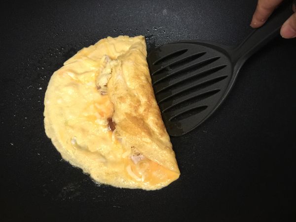 趁蛋汁還沒完全凝固前開始將蛋捲起來。