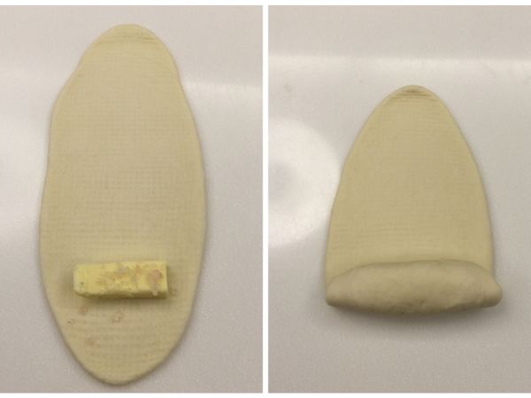 將麵糰擀平，放入無鹽奶油塊及少許的鹽巴，從奶油這端開始捲起。