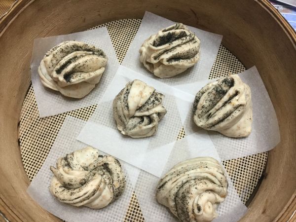 繞捲成形鋪上包子紙入蒸籠進行發酵