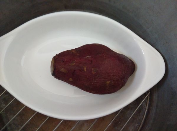 將金時地瓜洗淨，用盤子裝盛放入傳統電鍋中，外鍋加一米杯的水，蓋上鍋蓋，按下開關蒸煮到開關跳起來就可以了。