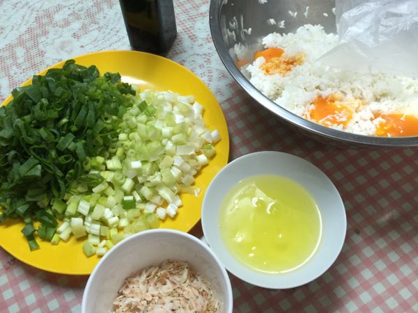 白飯放大盆用手略抓鬆；蛋黃與蛋白各自分開，將蛋黃放置飯盆裡；蔥切0.5cm的小段，蔥白蔥綠各自分開；蝦皮洗淨瀝乾備用。
