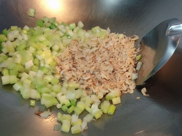 熱鍋放兩大匙冷油待油溫升高出現油紋即降中火，放入蔥白與蝦皮爆出香氣。