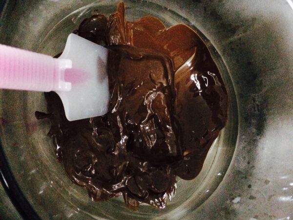 將巧克力以隔水加熱的方式邊攪拌溶解，水溫不超過50度以免巧克力油脂分離。