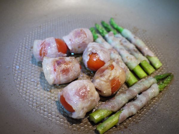 在平底鍋中放入少許油，用廚房紙巾塗抹均勻。再將「步驟2」捲好之蕃茄與蘆筍放入鍋中排好，記得肉片的接口要朝下，以中火煎至密合後，再滾動翻面，直至肉片微焦噴香，以及蕃茄軟化、皮微皺，即可灑上適量岩鹽，熄火盛盤。