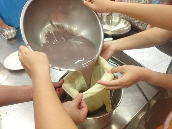 將濾出來的豆沙倒入豆漿濾布中，用手慢慢擠壓濾布將豆沙的水排除