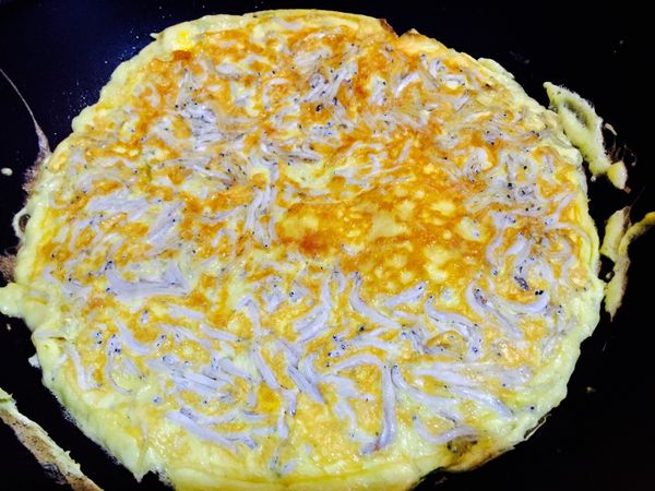 打開鍋蓋，以同等烘蛋圓面積之餐盤或鍋蓋襯翻鍋。翻面後的烘蛋轉大火快煎1分鐘逼出蛋香即可起鍋。