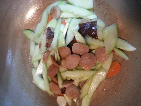 原鍋再倒入少量的油爆香蒜頭,蔥白,紅蘿蔔,木耳及黃瓜片拌炒後,將做法3的貢丸水及作法2的貢丸片一起加入拌炒,待湯汁快收乾時再放入蔥綠及辣椒片,起鍋前加鹽,胡椒粉,香油調味即可.