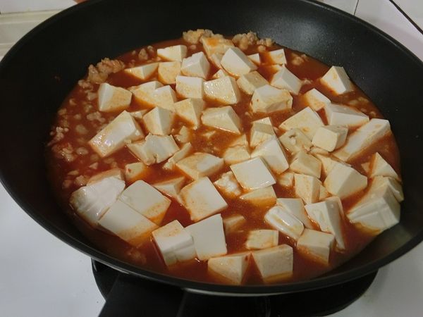 水滾後放入豆腐（因個人偏愛嫩豆腐，可使用板豆腐較易吸汁），蓋鍋悶煮約３分鐘。