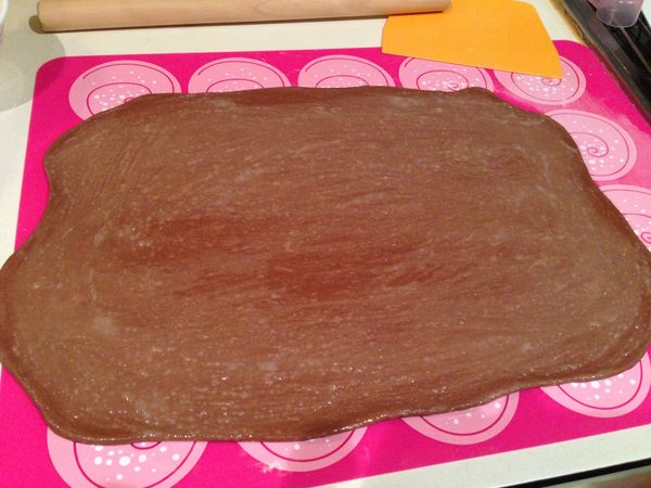 把純黑巧克力切碎加入高+低筋麵粉一起打麵糰，將打好並完成基發的麵糰桿平0.3公分厚度(盡量成長方形)。