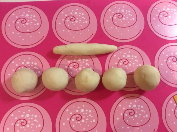 每一個麵團再均分切割成六個，其一捲成長條狀，另五個滾圓