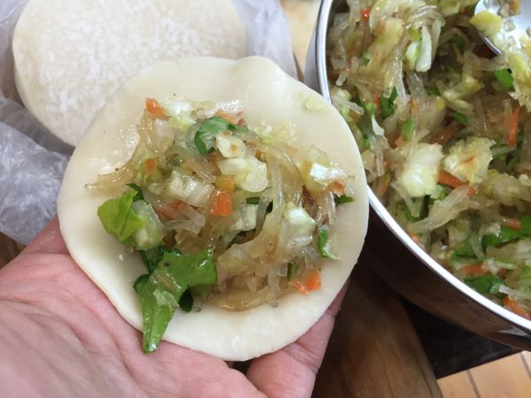 取適量餡料放餃子皮上包成餃子狀