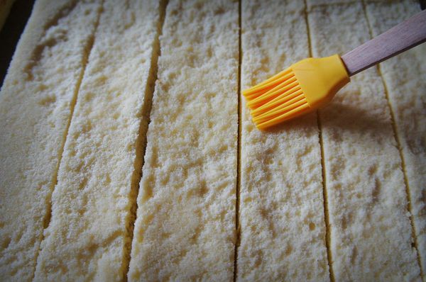 將蛋糕未上色那面朝上塗上酒糖液並均勻抹上1/2的打發鮮奶油。