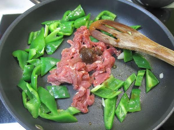 再加入牛肉片和一匙沙茶拌炒至半熟