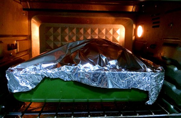 5. 準備一個盤子上面放個鐵架，把土雞放在鐵架上面、再用鋁箔紙包住土雞、溫度230烘烤40分鐘（第一次烘烤）。