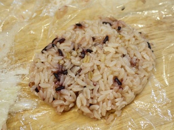 撕一張保鮮膜，將微波完稍稍放冷的飯放到保鮮膜上塑型