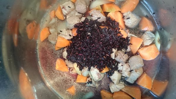 倒入油將洋蔥炒到軟後加入肉 跟蘿蔔 最後再倒入紫米 馬鈴薯 芝麻粉