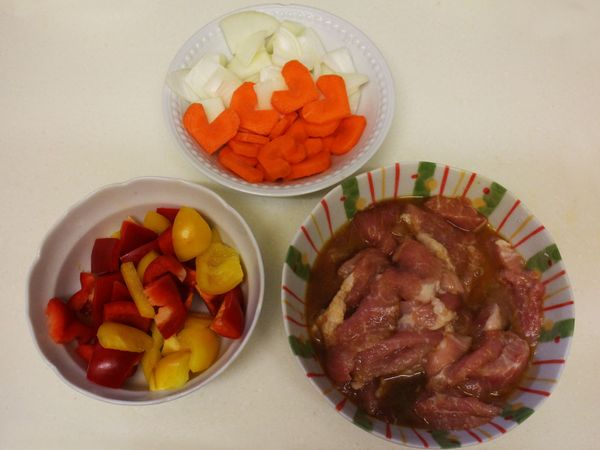 醃好的豬里肌肉，切塊的紅甜椒、黃甜椒、紅蘿蔔與洋蔥，準備下鍋油炸。