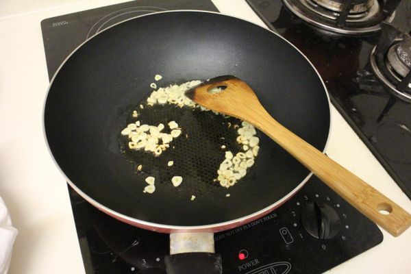 先熱油鍋，炒蒜片至蒜香四溢。