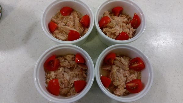 鮪魚肉(含湯汁)分裝於4杯烤盅內，
小番茄分切4等份，等分擺放鮪魚上方。
