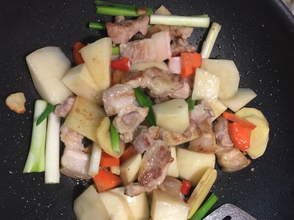 熱鍋後將五花肉、蔥段、薑、蒜、辣椒爆香，再加入馬鈴薯、紅蘿蔔、皇帝豆拌炒