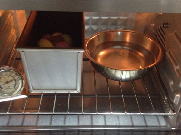 麵團放入吐司模裡，放進烤箱發酵，放入一盆熱水幫助發酵，水冷了就再換一次。