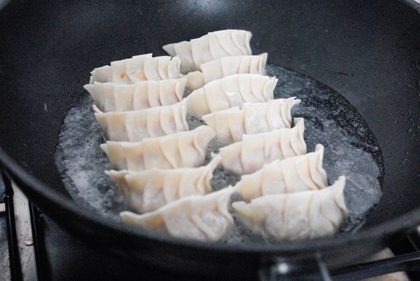 熱鍋下油，然後排好餃子，加約150毫升水，蓋上鍋蓋，以大火煮3分鐘