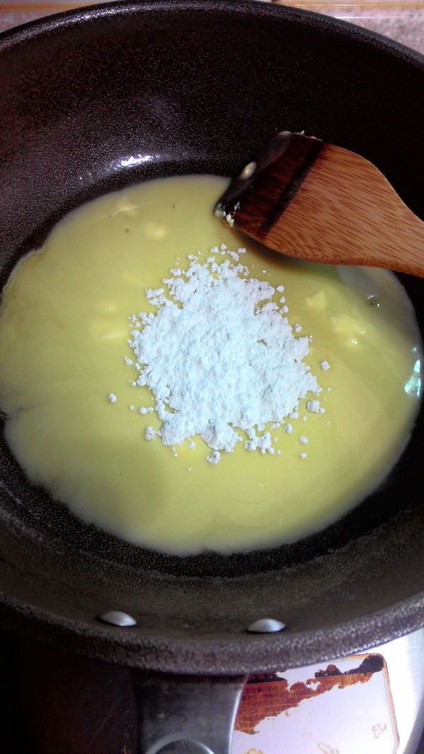 奶油融化後，分多次加入已過篩的低筋麵粉，拌炒均勻呈無粉狀。