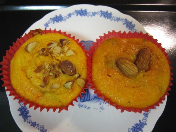 將麵糊倒入瑪芬模具內，8分滿即可，並在表面上用完整的杏仁堅果裝飾，用手輕按使其穩定（圖:為出爐後之成品）。