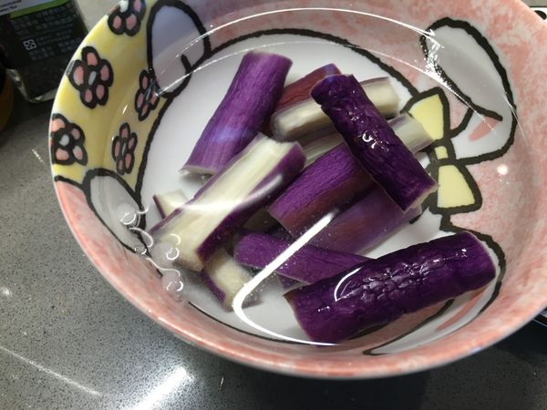 滾水加少許鹽再放入板豆腐和茄子，用網勺將茄子壓進滾水中，撈起泡冰水顏色才漂亮