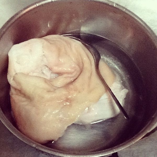 燙好的蹄膀沖冷水降溫後，用湯匙用力的刮豬皮，去掉剩餘的雜質。如果還有多的豬毛就拔掉它！這樣才吃得安心~