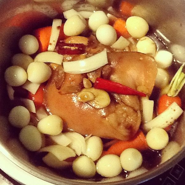 把蹄膀移入鍋子哩，放入[配料]。配料有洗乾淨的整根的小紅蘿蔔(不去皮)、鵪鶉蛋。[調味料]洋蔥、薑片、蒜片、辣椒也放進去。倒入米酒、醬油各半碗，再加入水蓋過材料的3/2。