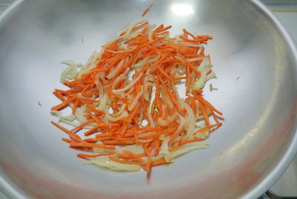 起油鍋（油多放一點），放入洋蔥絲炒至透明後，再放入紅蘿蔔絲翻炒。