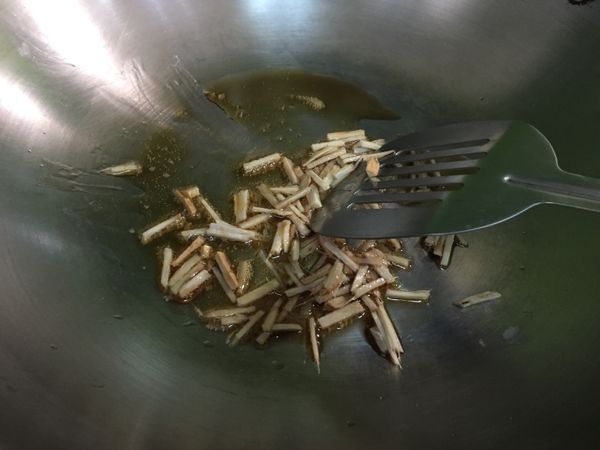 炒鍋放一大匙麻油，開小火稍微熱鍋後，加入薑煸香（一樣開小火），炒至薑皺縮呈微焦色。