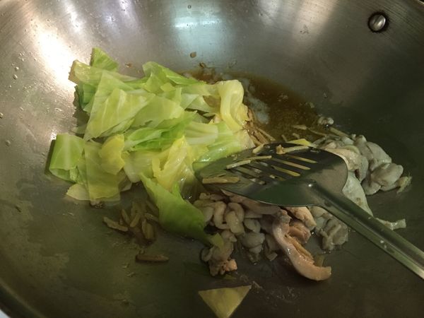 雞肉炒熟後，加入已燙過之高麗菜稍微拌炒即先盛盤備用。